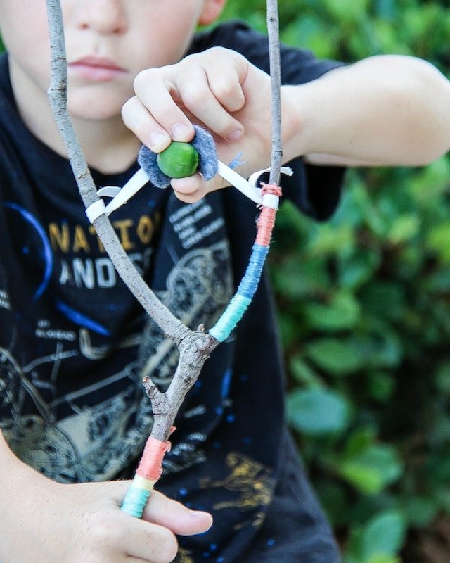 A young guest focuses on target practice with a handmade slingshot at the Preserve Resort & Spa's crafting experience.
