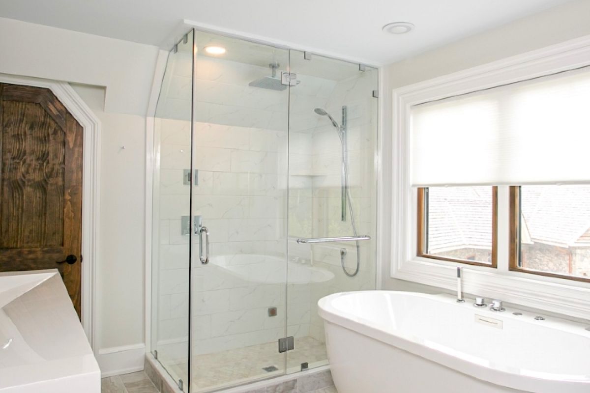 A modern bathroom with a glass shower enclosure, freestanding bathtub, double vanity, mirror, and wooden door. Bright and minimalistic design.