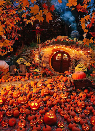 A whimsical autumn scene with a round door, surrounded by lit jack-o'-lanterns, leaves, and a scarecrow. Cozy, festive, and enchanting.