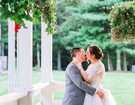 Couple sharing a kiss on a scenic porch at The Preserve Sporting Club & Resort.