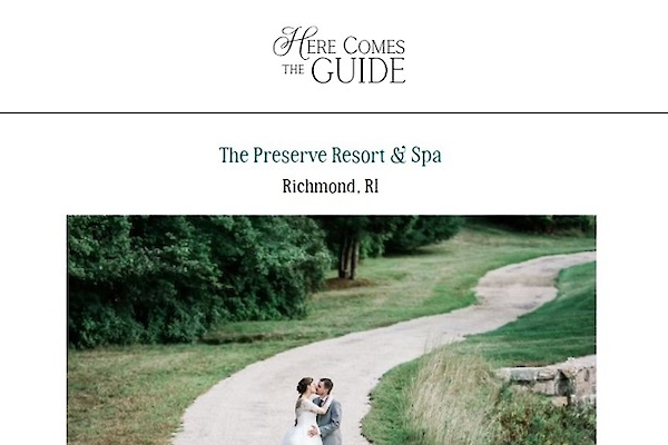 A couple in wedding attire poses on a path surrounded by greenery at The Preserve Resort & Spa, Richmond, RI. Venue: Four-Season Resort.