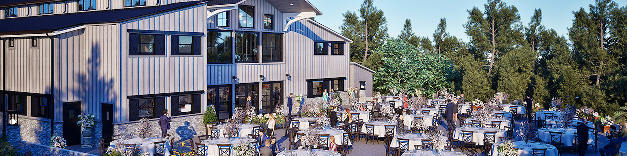 An outdoor event at a large building with many tables, chairs, and guests, set amidst greenery and trees under a clear blue sky.