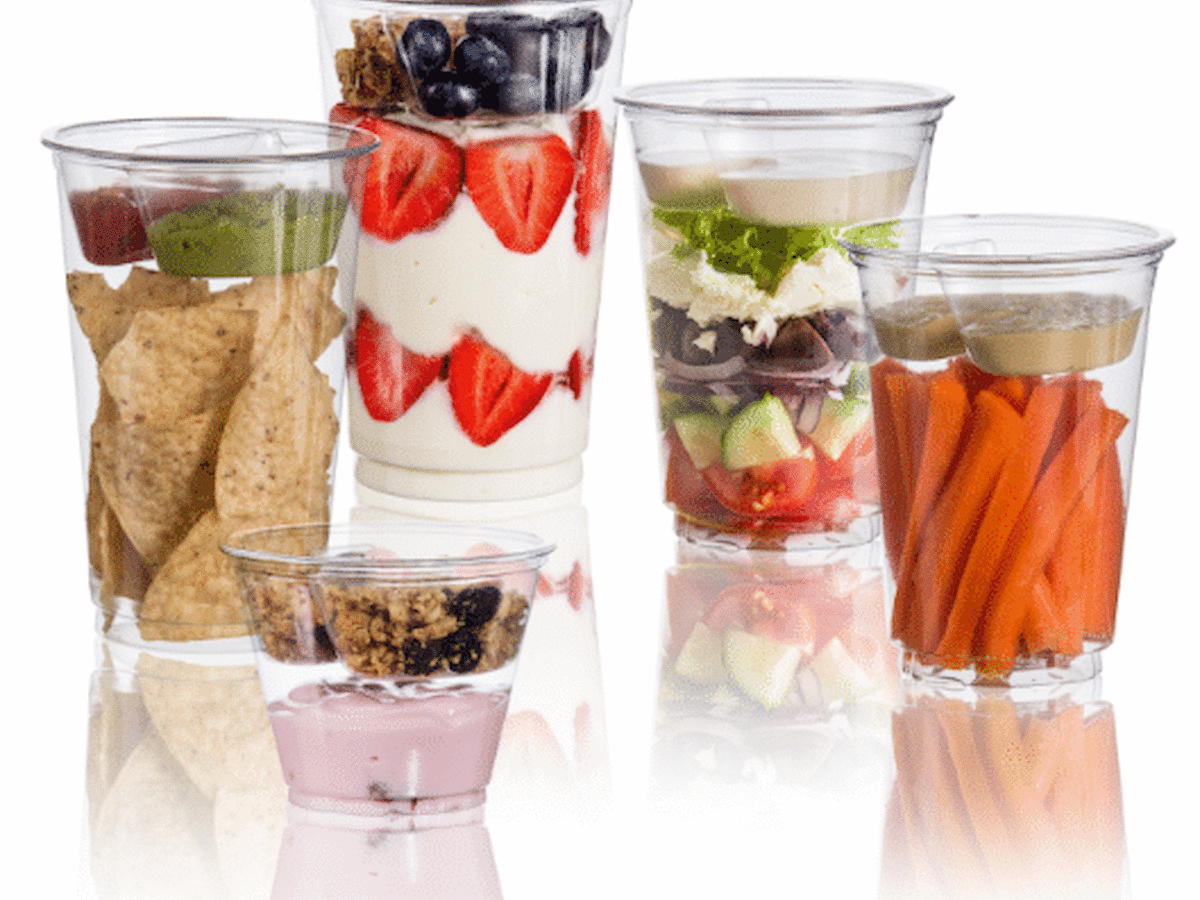 The image shows various clear cups containing snacks and ingredients, including yogurt with fruit, veggies, chips, and granola.
