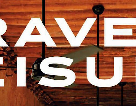 The image shows the text "TRAVEL + LEISURE" over an indoor background with wooden ceiling and beams.