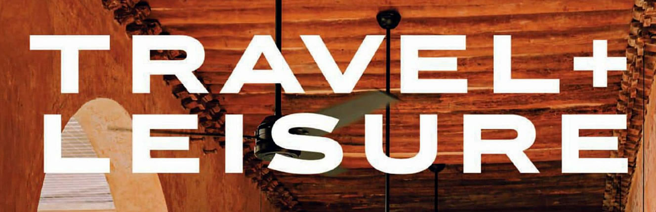 The image shows the text "TRAVEL + LEISURE" over an indoor background with wooden ceiling and beams.